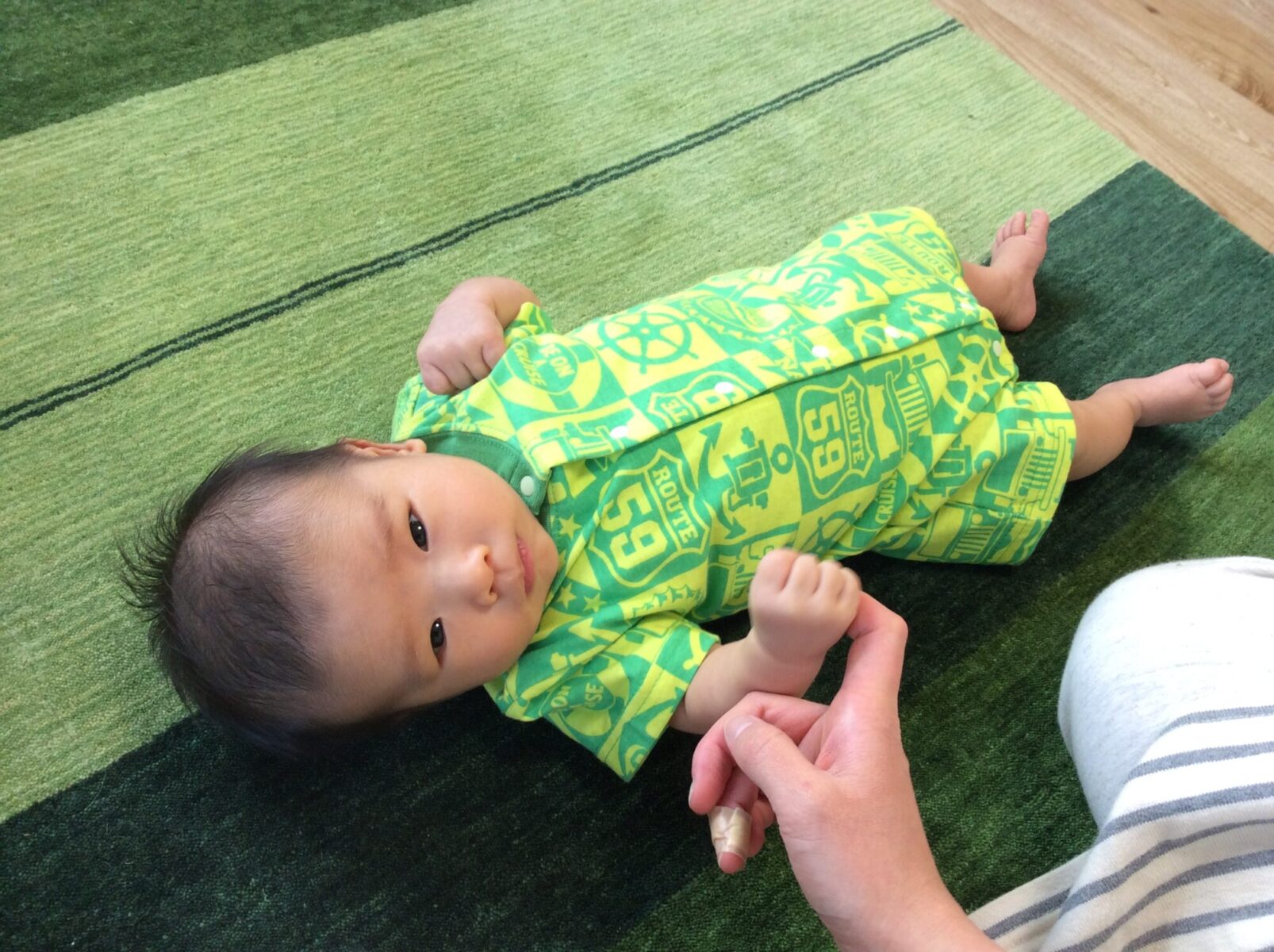 ハグみじゅうたんに寝転ぶ赤ちゃん