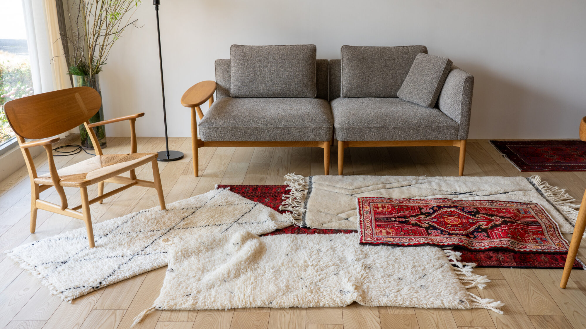 部族模様が特徴的なトライバルラグを床に敷いたリビング空間の実例